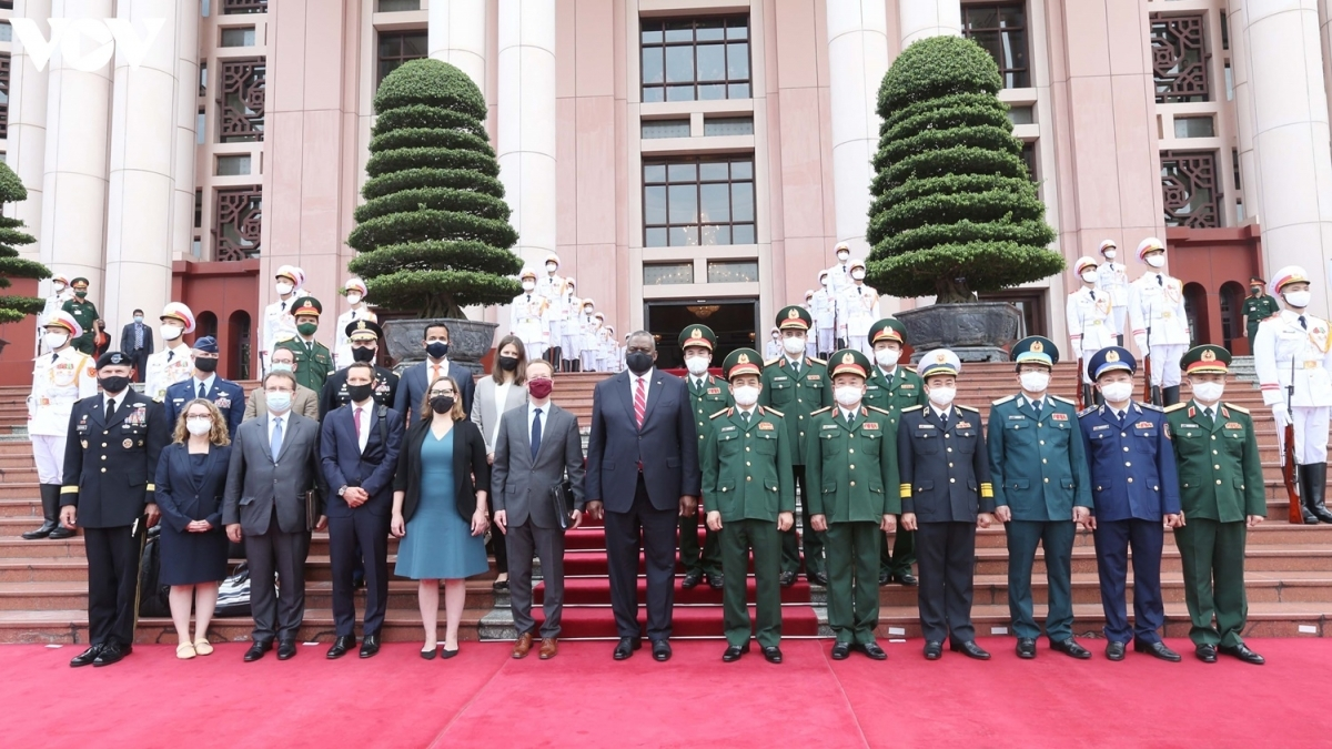 Minister Phan Van Giang and Secretary Lloy Austin (C) pose for a group photo in front of the Headquarters of the Defence Ministry in Hanoi.