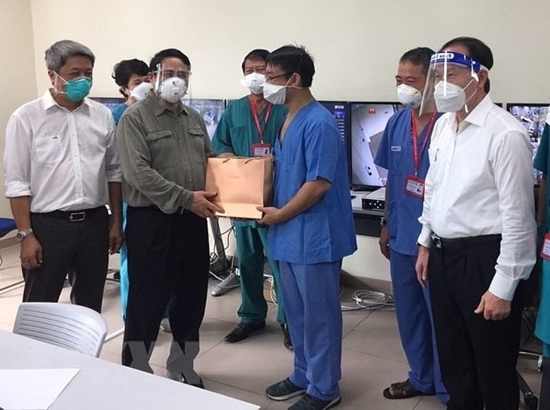 Prime Minister Pham Minh Chinh visits and presents gifts to doctors and nurses who are treating Covid-19 patients at Becamex Intensive Care Field Hospital, Binh Duong province. 