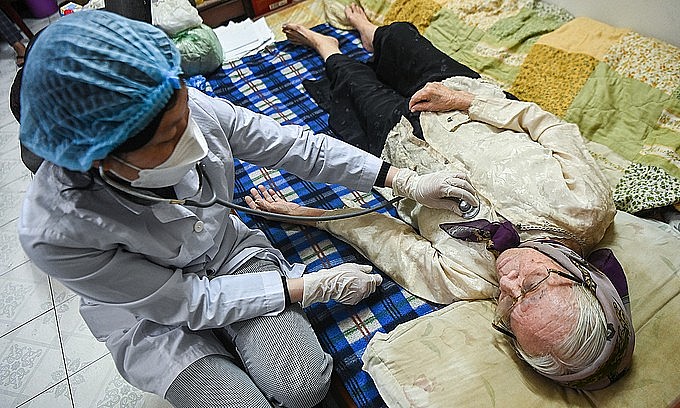 A Hanoi woman has her health checked before Covid-19 vaccination, January 2022. Photo: VnExpress
