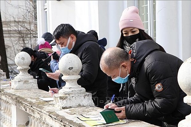 Vietnamese citizens fill in necessary forms at the embassy in Romania. Photo: VNA