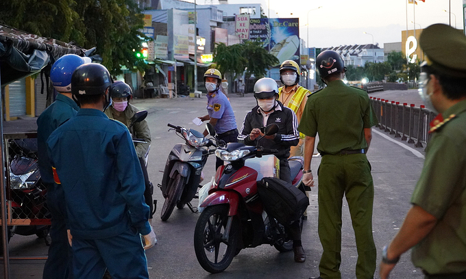 Police officers at a Covid-19 checkpoint stop vehicles in HCMC's Go Vap District, July 26, 2021. Photo: VnExpress