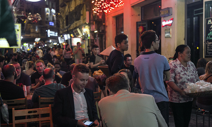 Foreign tourists sit at a beer stall in Ta Hien-Luong Ngoc Quyen intersection in Hanoi, 2019. Photo: VnExpress