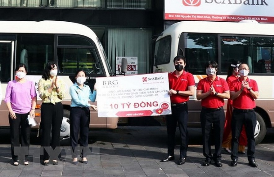 The COVID-19 prevention and control fund of HCM City receives the token of ten 29-seater buses from donors. Photo: VNA