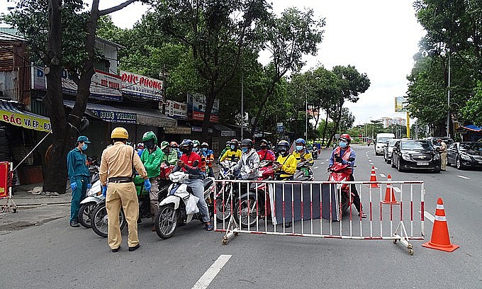 Several shippers are stopped at a Covid-19 checkpoint on Dinh Bo Linh Street, Binh Thanh District, HCMC, July 25, 2021. Photo: VnExpress