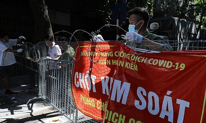 A task force removes a barricade at a Covid-19 checkpoint in Hanoi's Hoan Kiem District, Sept. 21, 2021. Photo: VnExpress