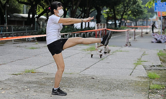 A woman does morning exercise at a park in HCMC, October 1, 2021. Photo: VnExpress