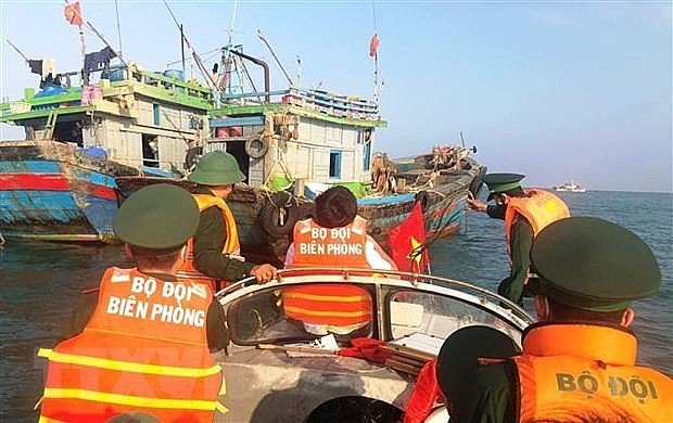 Border guards in Quang Binh province examine a fishing boat and disseminate legal regulations to fishermen. Photo: VNA