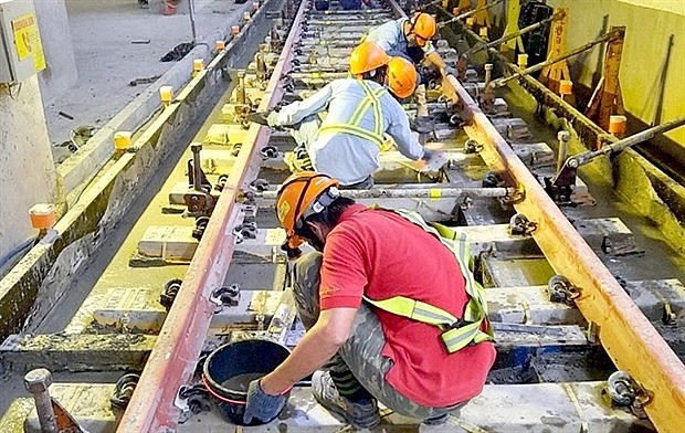 Construction workers complete work on two underground railway tracks of HCM City's Metro Line No. 1. Photo: MAUR